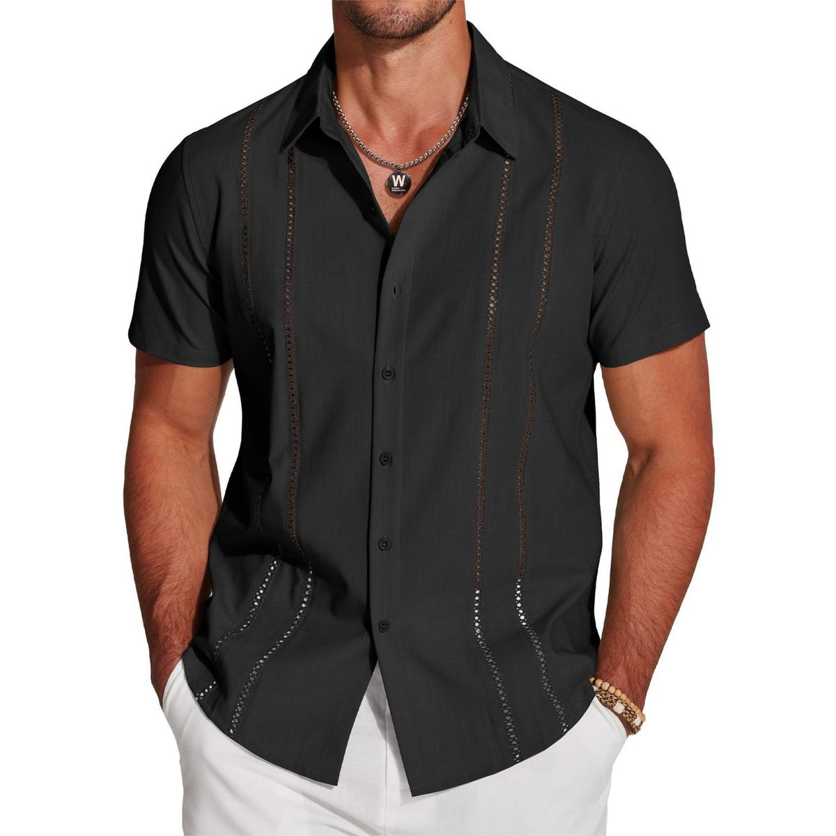 Man wearing a black short-sleeve shirt with decorative stitching on a white background