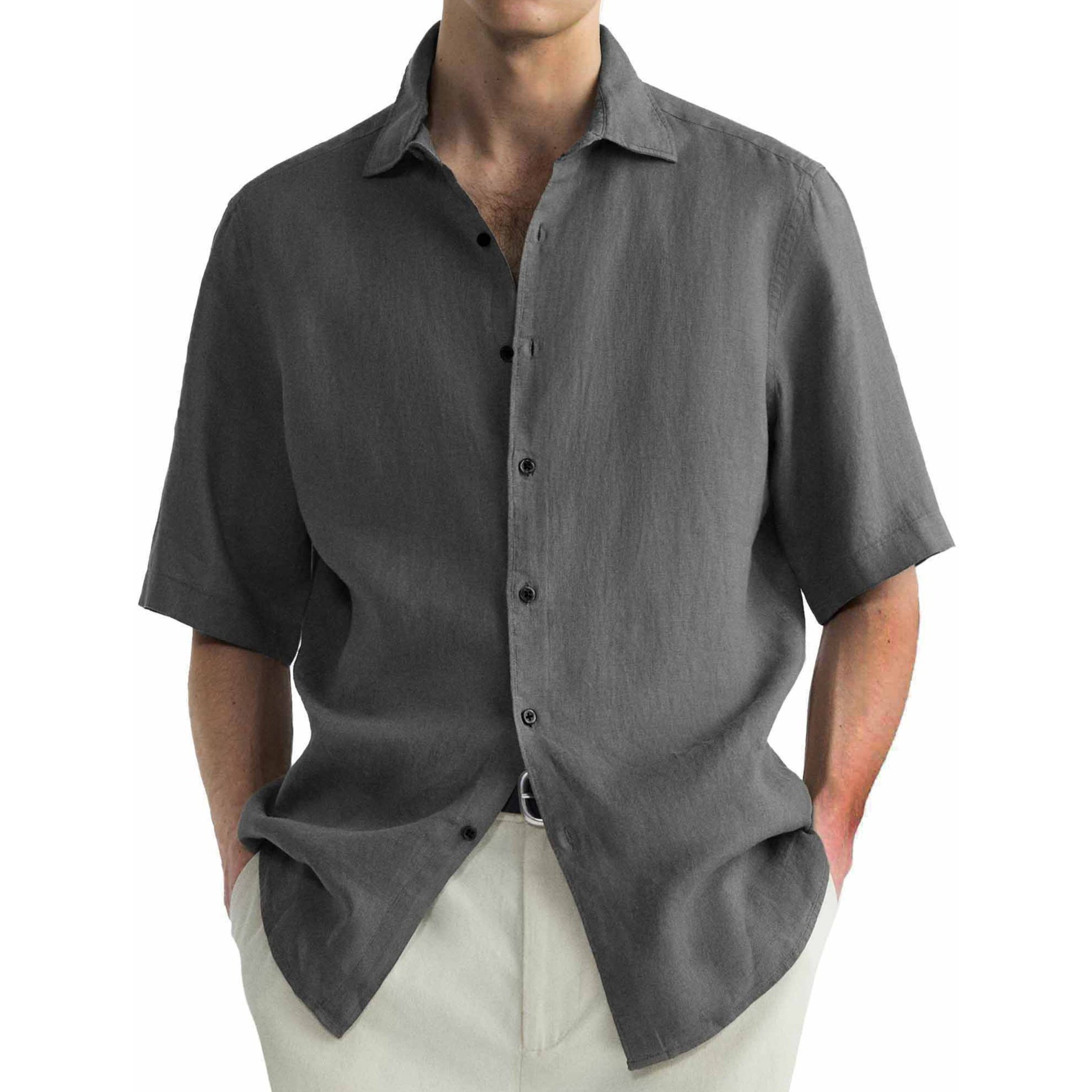 A man wearing a gray short-sleeved washed cotton shirt with a collar, button-up front, and light-colored pants.