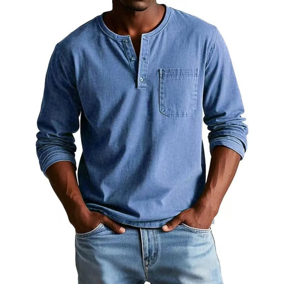 Man wearing a blue long-sleeve henley shirt and jeans on a white background