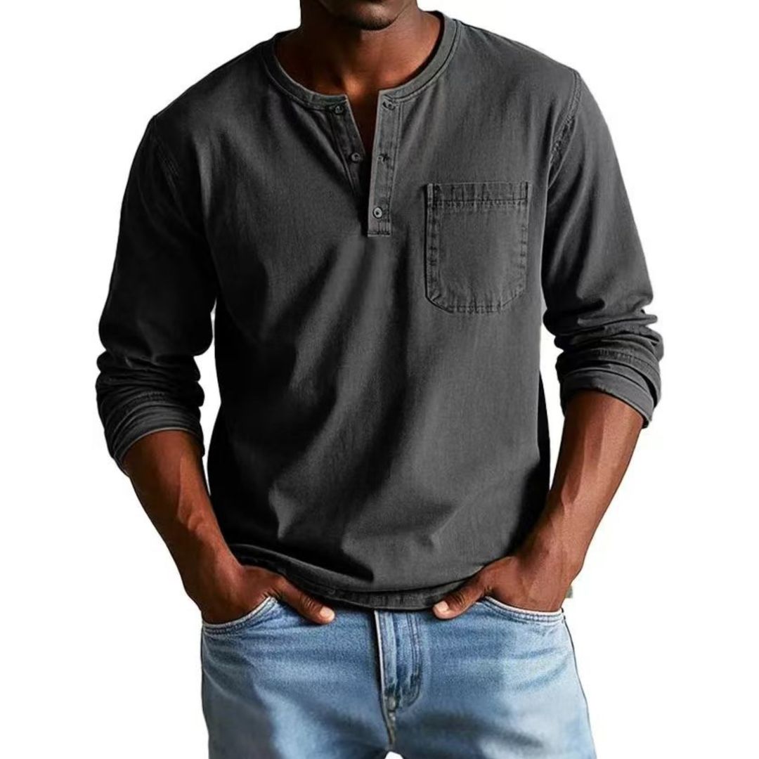 Man wearing a dark gray long-sleeve henley shirt and light blue jeans on a white background