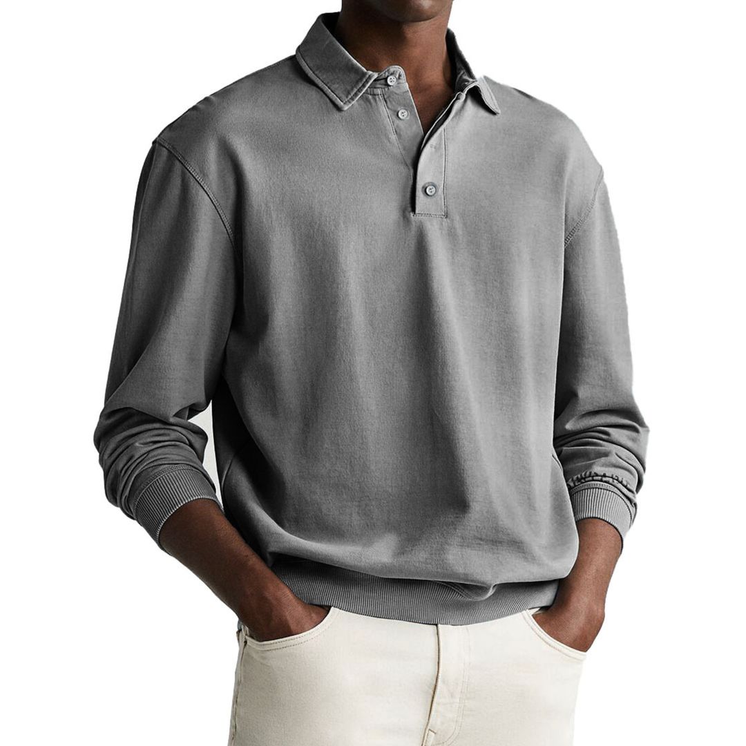 A man wearing a gray long-sleeve polo sweatshirt with a collar and a three-button placket.