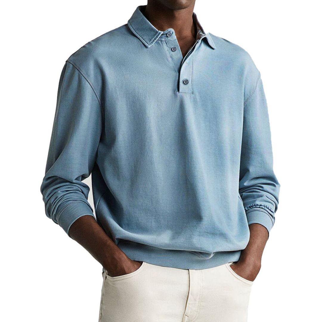 A man wearing a gray long-sleeve polo sweatshirt with a collar and a three-button placket.