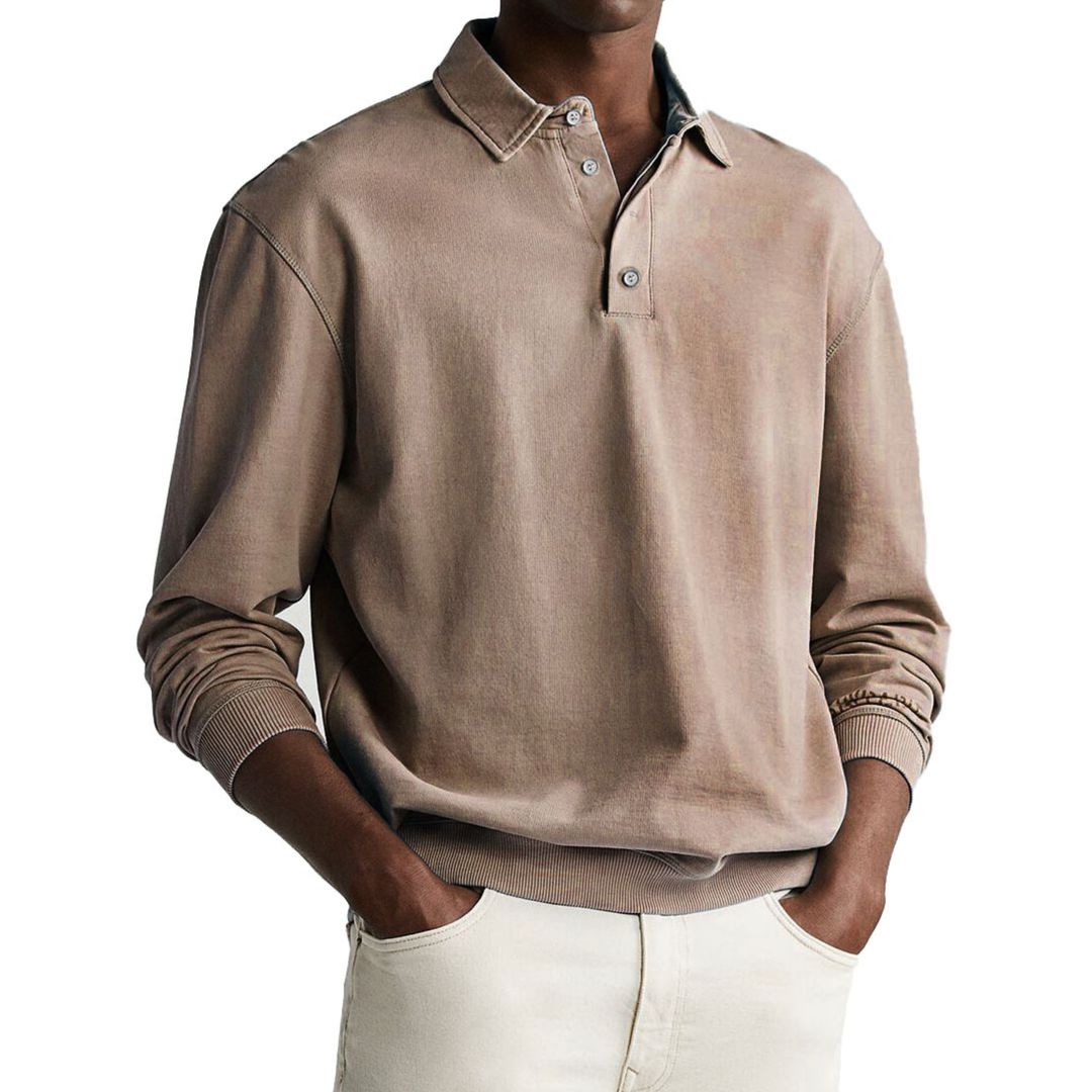 A man wearing a gray long-sleeve polo sweatshirt with a collar and a three-button placket.