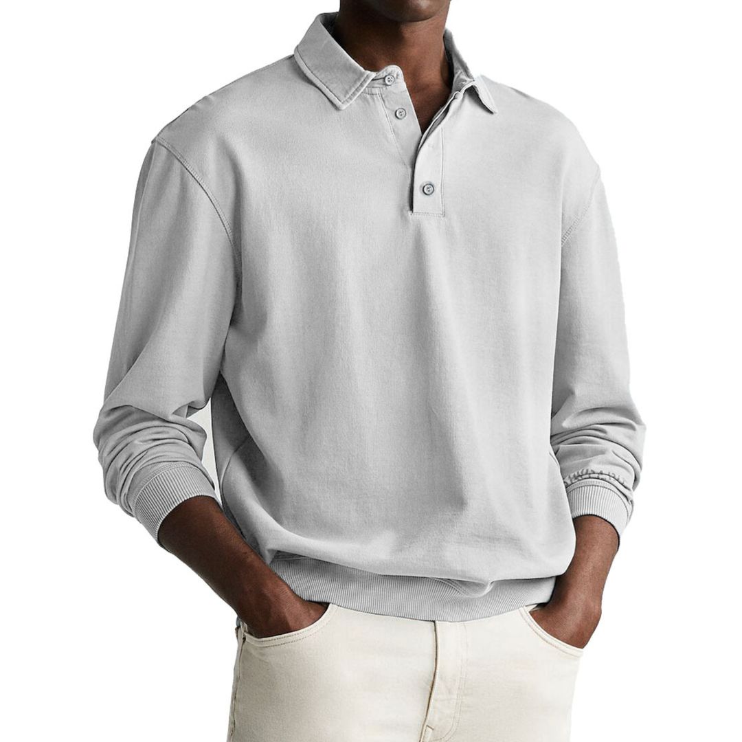 A man wearing a gray long-sleeve polo sweatshirt with a collar and a three-button placket.
