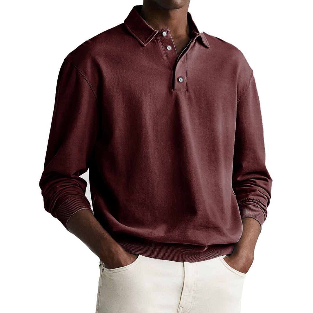 A man wearing a gray long-sleeve polo sweatshirt with a collar and a three-button placket.