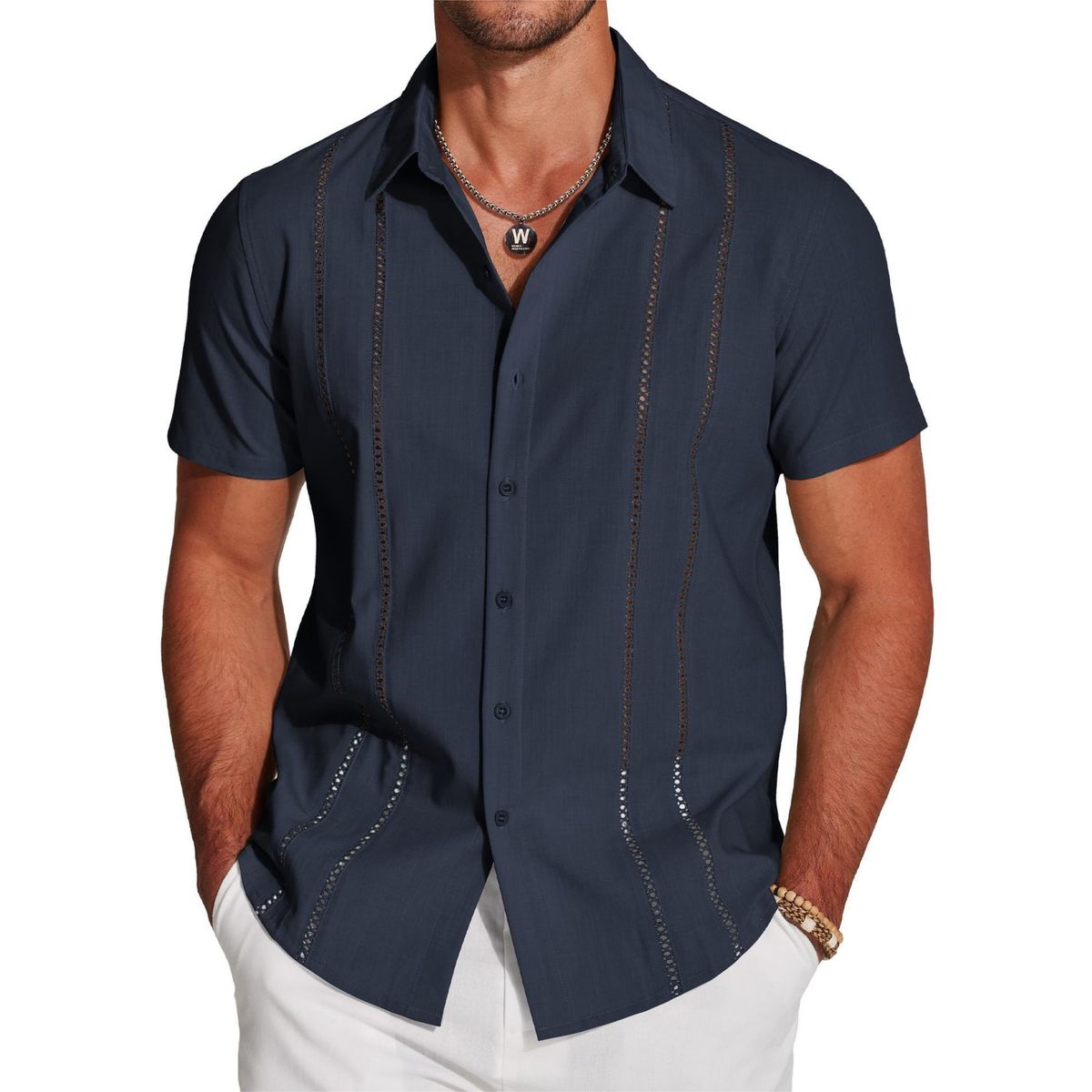 Man wearing a navy blue short-sleeve shirt with decorative stitching on a white background
