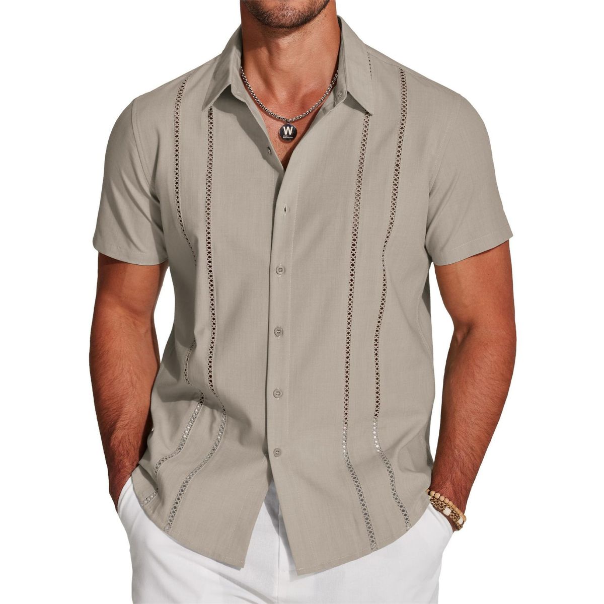 Man wearing a beige short-sleeve shirt with decorative stitching on a white background