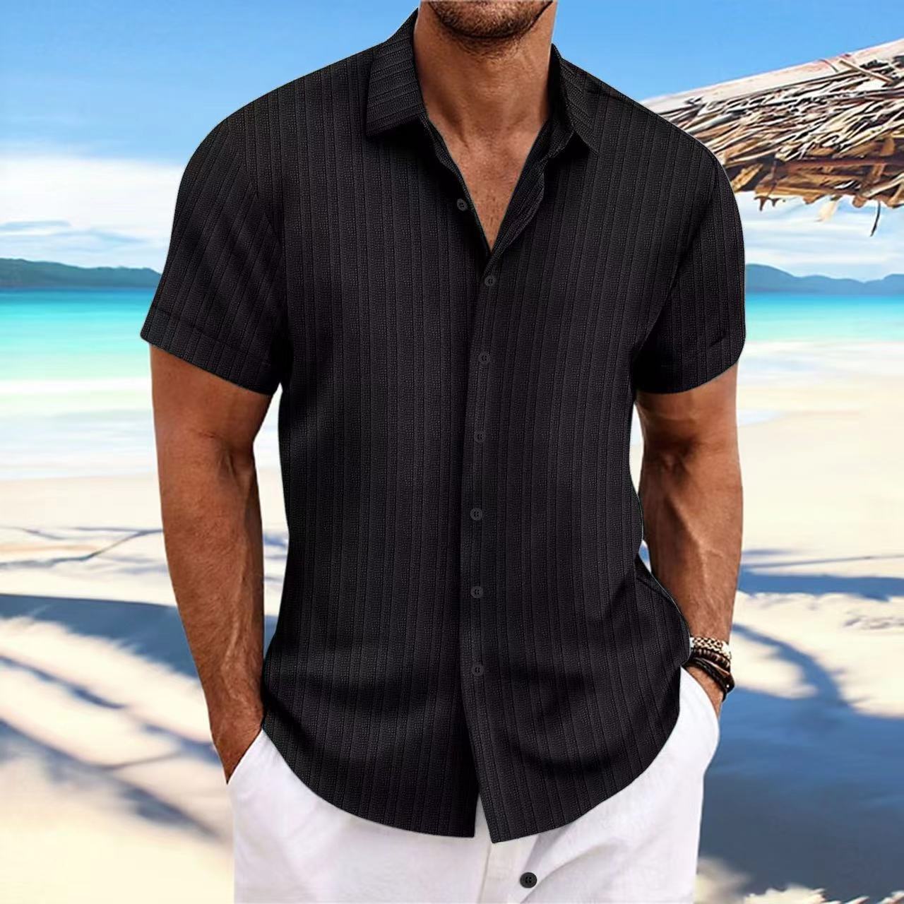 Man wearing a black pinstripe shirt on a beach