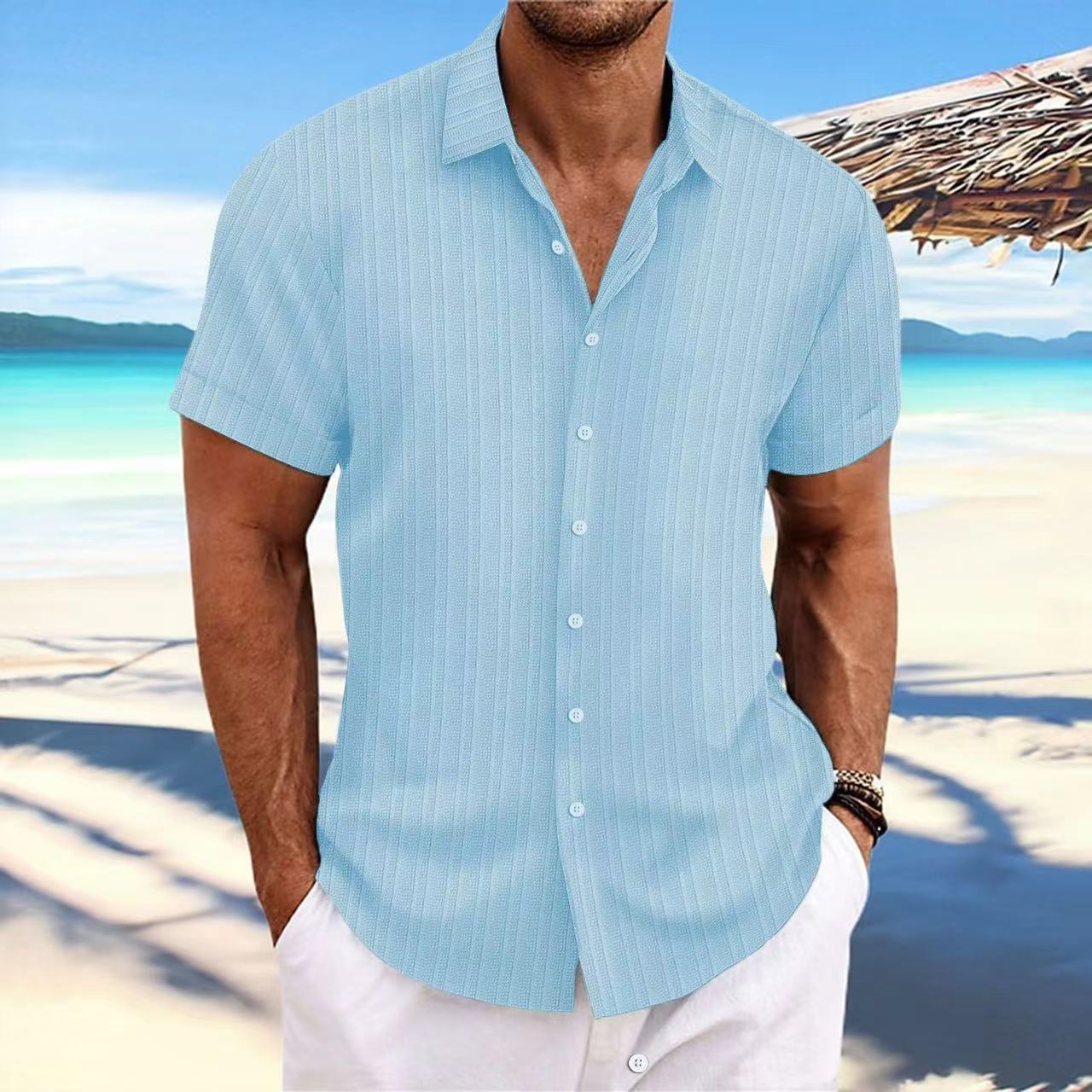 Man wearing a light blue striped shirt on a beach