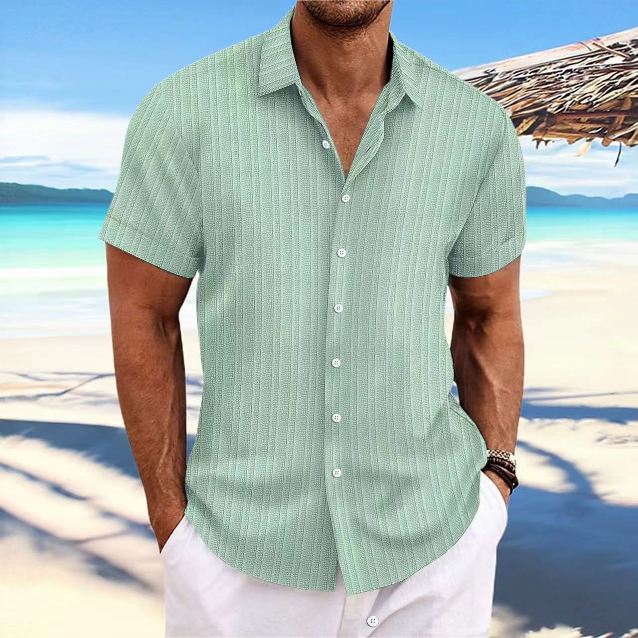 Man wearing a light green striped shirt on a beach