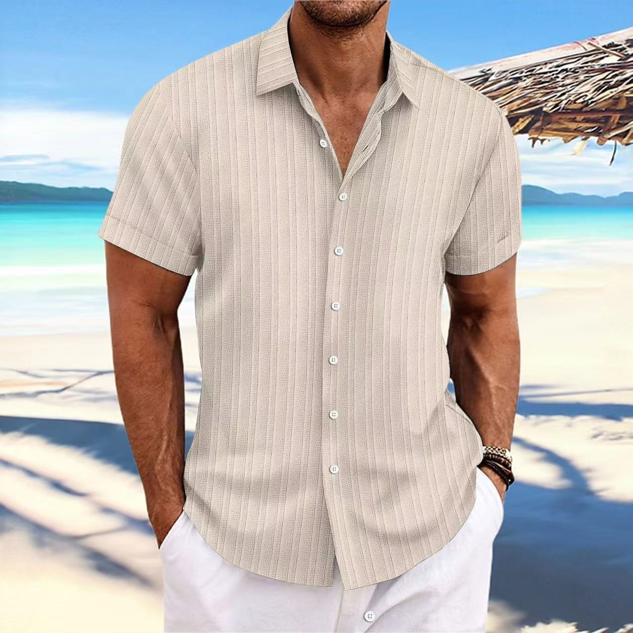Man wearing a beige striped shirt and white pants on a beach