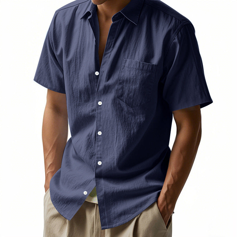 Navy blue short-sleeve shirt worn by a person on a white background