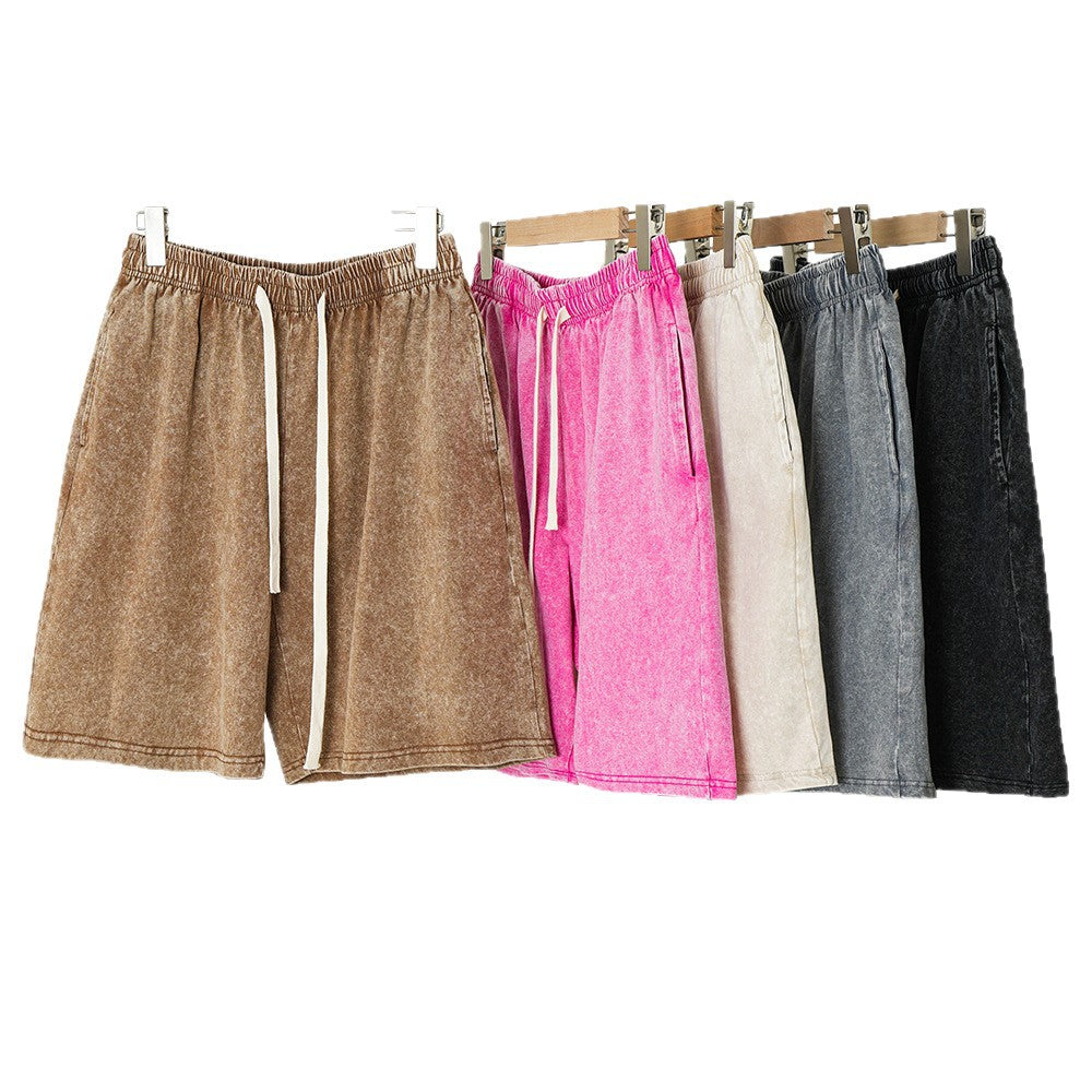 Set of four shorts in brown, pink, beige, and black on hangers against a white background.